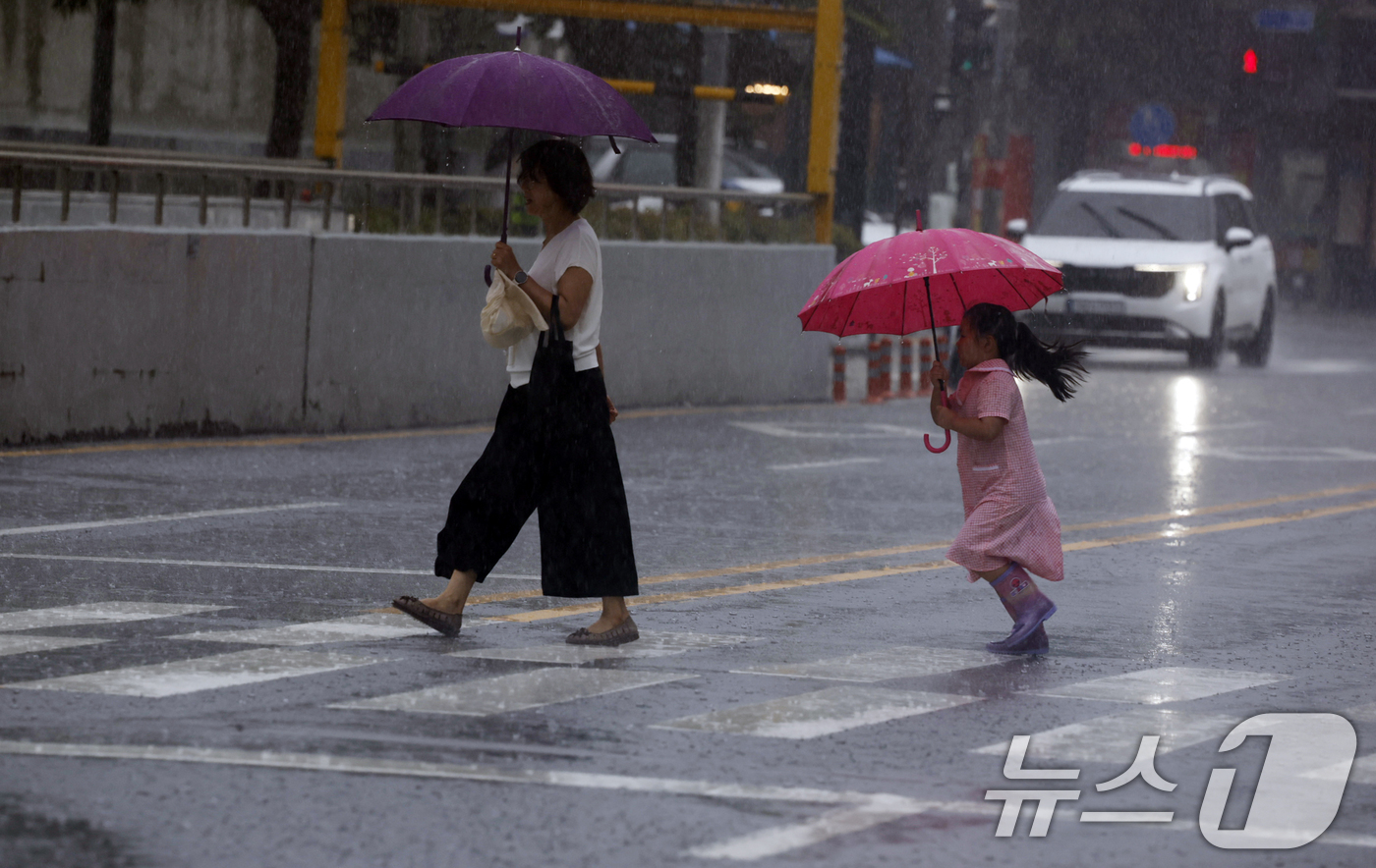 (광주=뉴스1) 김태성 기자 = 13일 광주전남 일부지역에 호우주의보가 발효된 가운데 동구 아시아문화전당 옆길에 시민들이 우산을 쓰며 걸어가고 있다. 2025.7.13/뉴스1