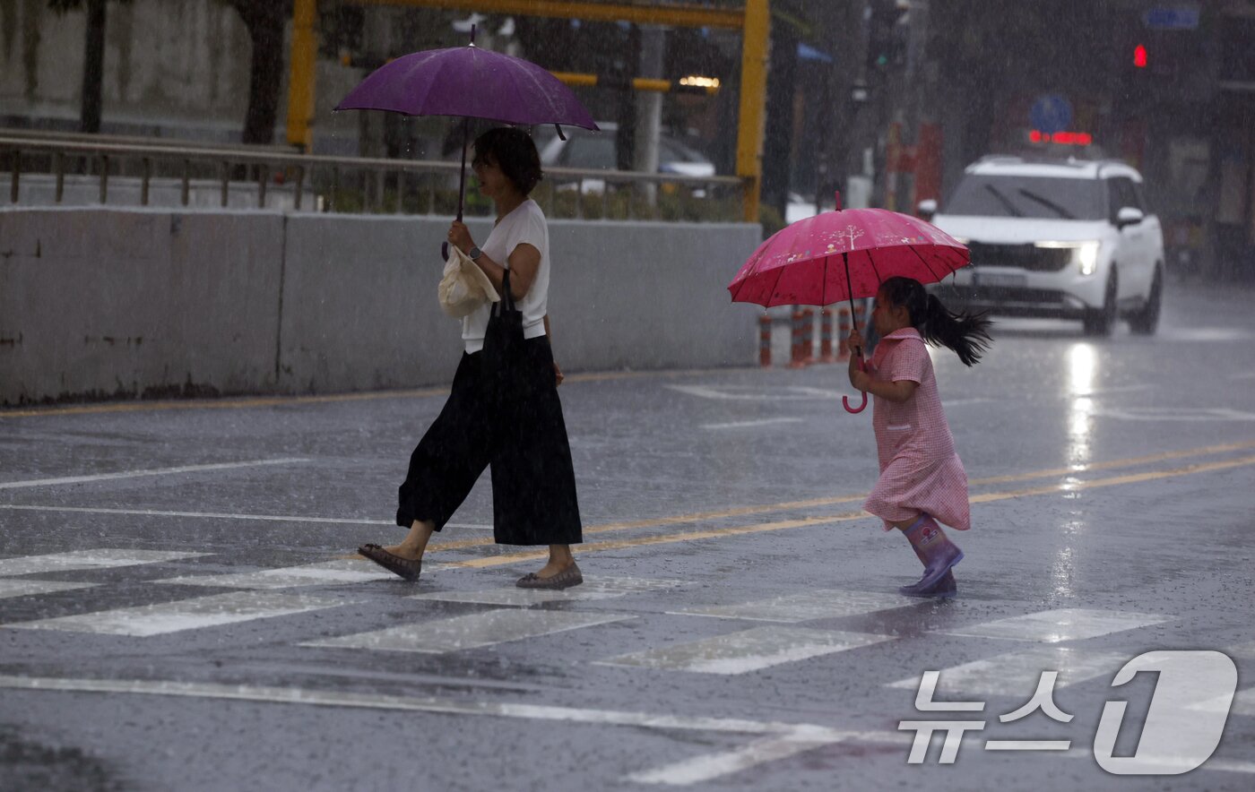 본문 이미지 - 13일 광주전남 일부지역에 호우주의보가 발효된 가운데 동구 아시아문화전당 옆길에 시민들이 우산을 쓰며 걸어가고 있다. 2025.7.13/뉴스1 ⓒ News1 김태성 기자