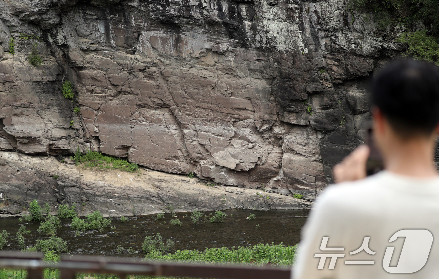 (울산=뉴스1) 조민주 기자 = 유네스코 세계문화 유산 등재가 확정된 울산 울주군 대곡리 반구대 암각화에서 13일 한 시민이 휴대폰 카메라로 암각화를 촬영하고 있다. 2025.7. …