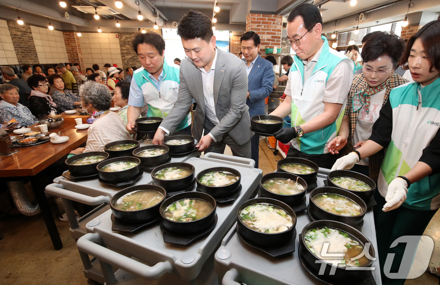 (대구=뉴스1) 공정식 기자 = 초복을 앞둔 14일 오전 대구 중구의 한 음식점에서 열린 '초복맞이 영약식 나눔 데이' 행사에서 각 기관 봉사자들이 어르신에게 갈비탕을 전달하고 있 …