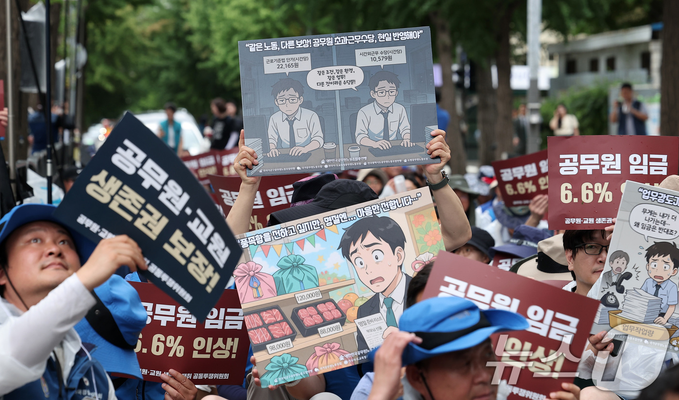 (서울=뉴스1) 김성진 기자 = 대한민국공무원노동조합총연맹 관계자들이 14일 서울 종로구 정부서울청사 앞에서 열린 공무원 임금인상 쟁취 2차 간부결의대회에서 손피켓을 들고 있다. …