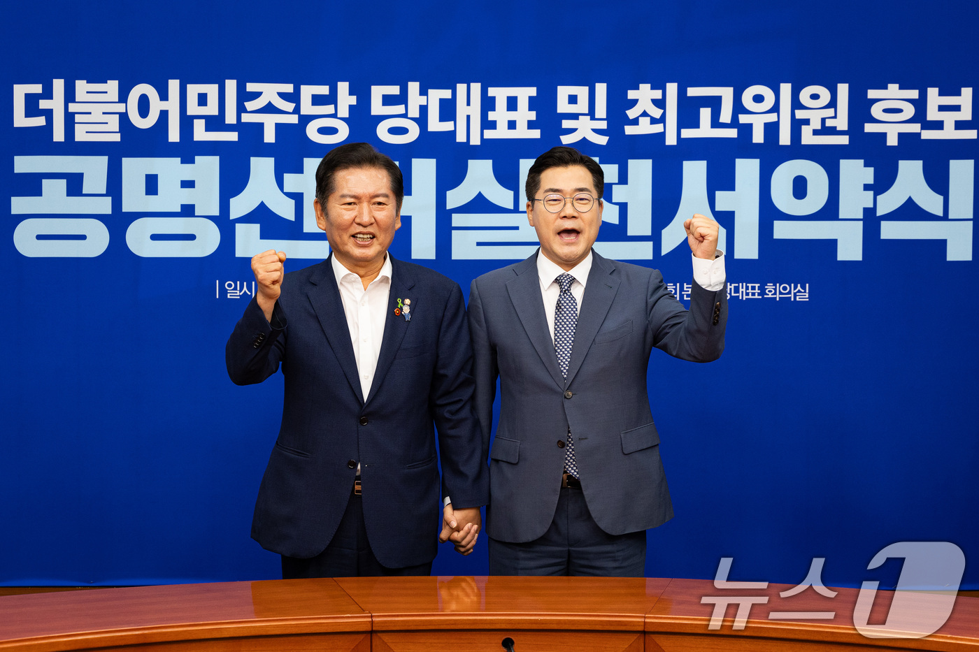 (서울=뉴스1) 유승관 기자 = 정청래(왼쪽), 박찬대 더불어민주당 당대표 후보가 15일 서울 여의도 국회에서 열린 공명선거실천서약식에서 서약서에 서명한 후 기념 촬영을 하고 있다 …