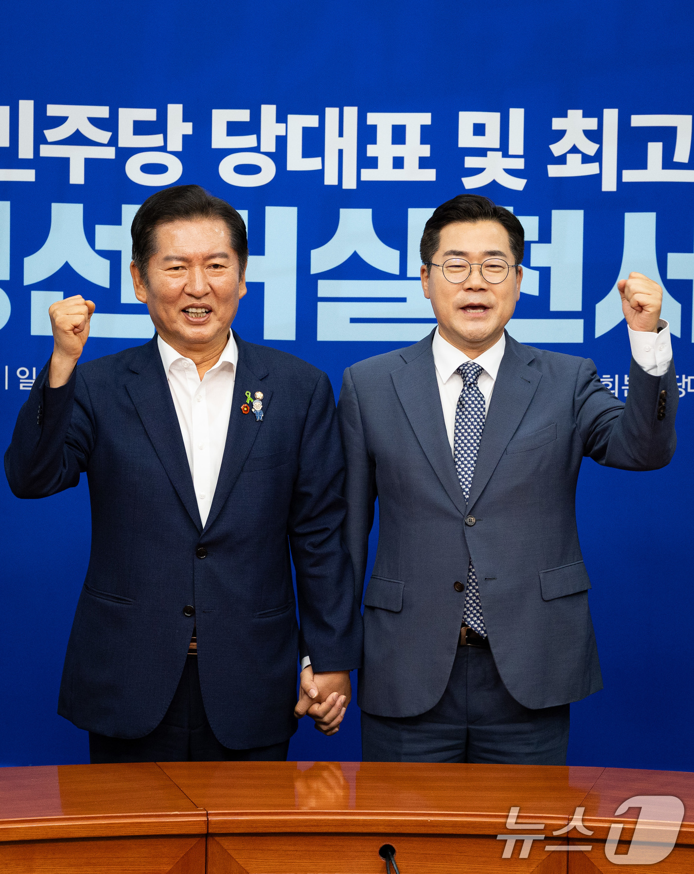 (서울=뉴스1) 유승관 기자 = 정청래(왼쪽), 박찬대 더불어민주당 당대표 후보가 15일 서울 여의도 국회에서 열린 공명선거실천서약식에서 서약서에 서명한 후 기념 촬영을 하고 있다 …