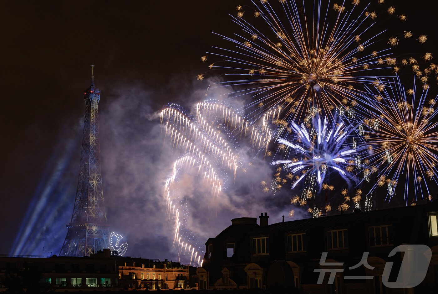 본문 이미지 - 14일&#40;현지시간&#41; 프랑스 혁명 기념일&#40;바스티유 데이&#41;을 기념하기 위해 에펠탑에 펼쳐진 불꽃놀이 쇼에서 1천100대의 드론이 불꽃과 함께 빛의 향연을 펼치고 있다. 2024.7.15/뉴스1 ⓒ News1 이준성 기자