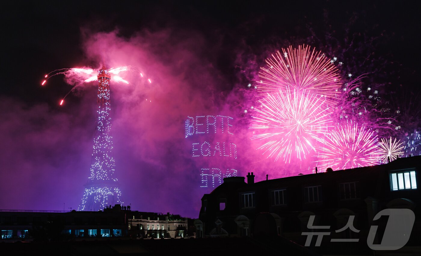 본문 이미지 - 14일&#40;현지시간&#41; 프랑스 혁명 기념일&#40;바스티유 데이&#41;을 기념하기 위해 에펠탑에 펼쳐진 불꽃놀이 쇼에서 1천100대의 드론이 프랑스의 국가 모토인 ‘자유・평등・박애’&#40;Libert&eacute; ・ &Eacute;galit&eacute; ・ Fraternit&eacute;&#41;를 파리 상공에 새기며 불꽃과 함께 빛의 향연을 펼치고 있다. 2024.7.15/뉴스1 ⓒ News1 이준성 기자