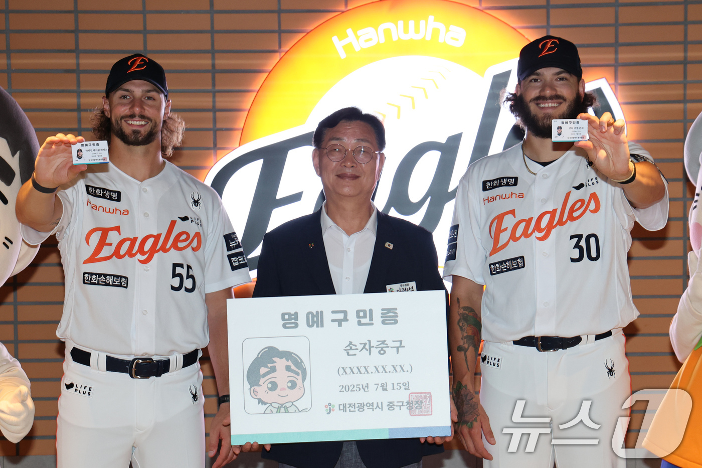 (대전=뉴스1) 김기태 기자 = 김재선 대전 중구청장이 15일 대전 한화생명 볼파크에서 한화이글스 외국인 투수 라이언 와이스(왼쪽)와 코디 폰세에게 명예구민증과 명예패를 전달한 뒤 …