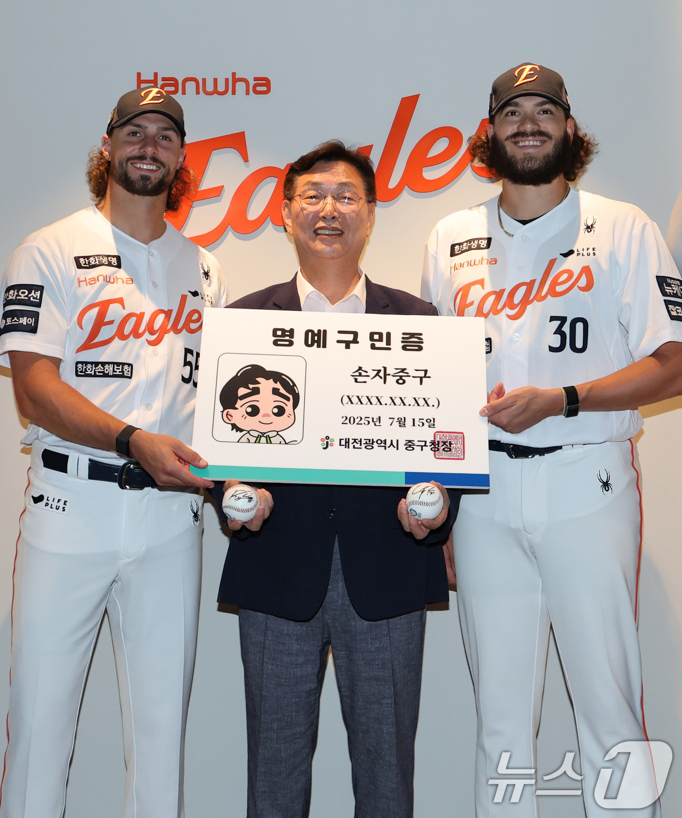 (대전=뉴스1) 김기태 기자 = 김재선 대전 중구청장이 15일 대전 한화생명 볼파크에서 한화이글스 외국인 투수 라이언 와이스(왼쪽)와 코디 폰세에게 명예구민증과 명예패를 전달한 뒤 …