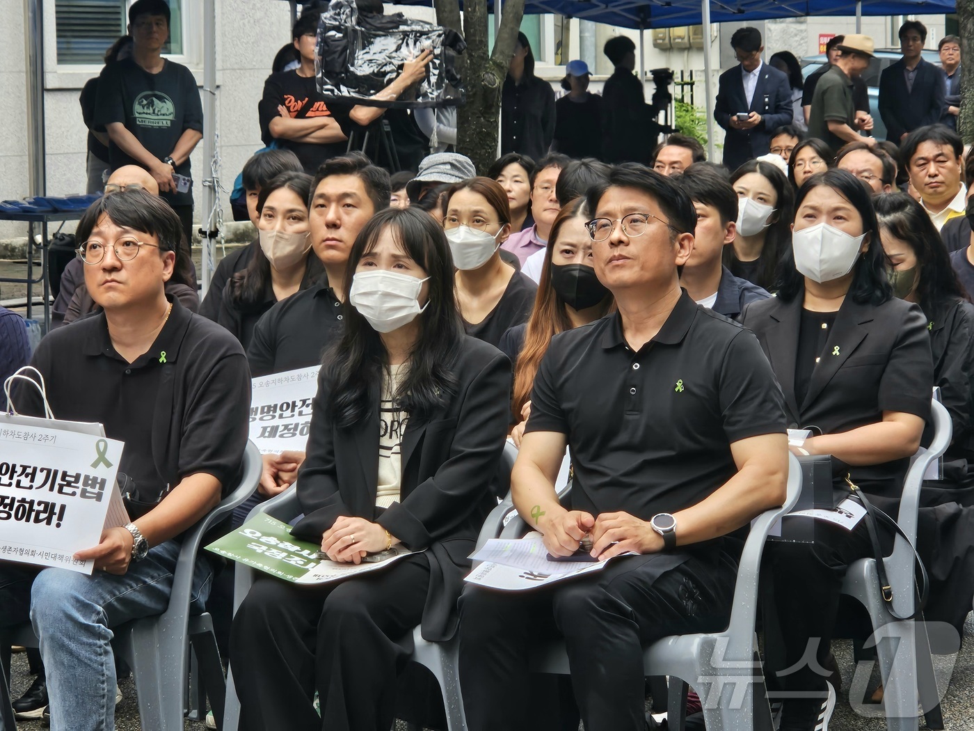 (청주=뉴스1) 이재규 기자 = 오송참사 2주기인 15일 최은경, 이경구 유가족협의회 대표가 충북도청 앞에서 열린 추모제에게 추모 영상을 보고 있다. 2025.7.15/뉴스1