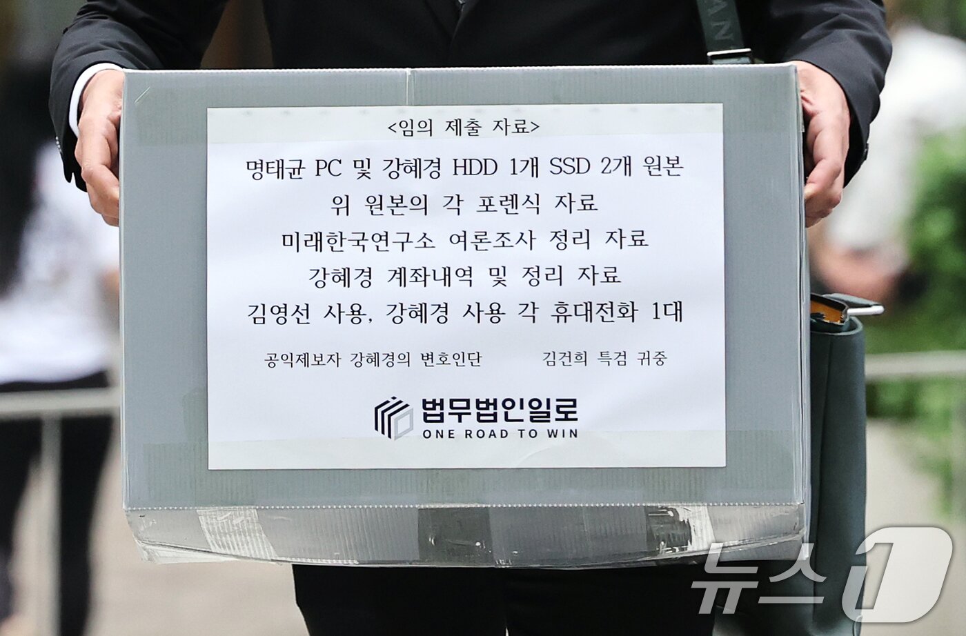 본문 이미지 - &#39;명태균 게이트&#39;를 최초 폭로한 전 미래한국연구소 부소장 강혜경 씨가 16일 오전 서울 종로구 KT광화문빌딩에 마련된 김건희 특검 사무실에 참고인 조사를 받기 위해 출석했다. 사진은 강씨의 법률대리인 문건일 변호사가 &#39;명태균 PC 및 여론조사 자료&#39; 등 임의 제출 자료를 들고 있는 모습. 2025.7.16/뉴스1 ⓒ News1 오대일 기자