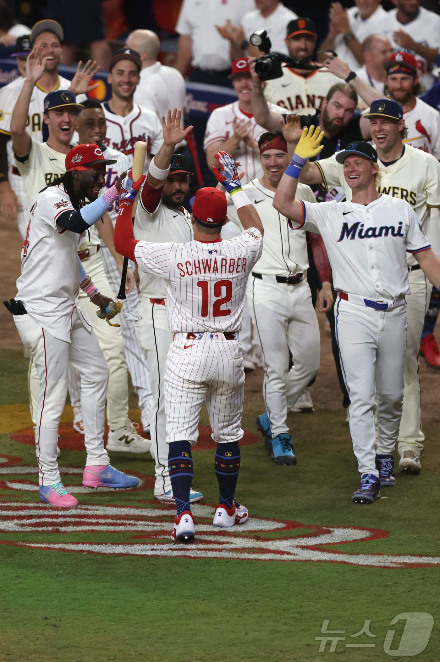 본문 이미지 - 필라델피아 필리스의 카일 슈와버가 16일&#40;한국시간&#41; 열린 2025 메이저리그 올스타전 스윙 오프에서 홈런 3개를 몰아친 뒤 내셔널리그 올스타 동료들의 축하를 받고 있다. ⓒ AFP=뉴스1