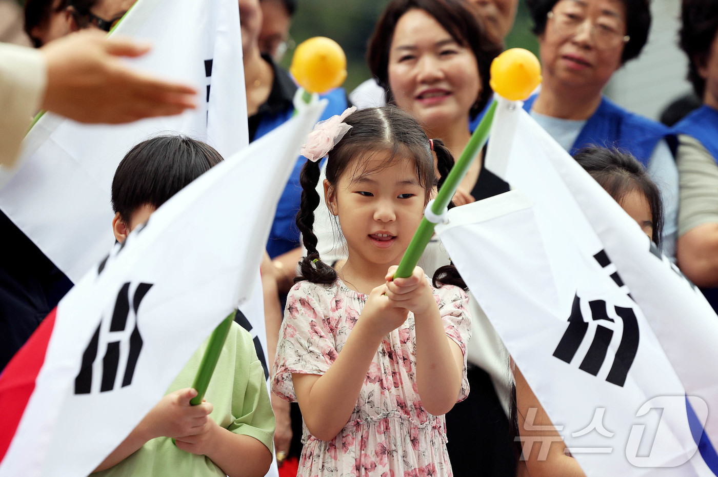 (광주=뉴스1) 박지현 기자 = 제헌절을 하루 앞둔 16일 광주 북구 신안동 중흥파크에서 열린 태극기 마을 조성 행사에서 문인 북구청장과 바르게살기운동북구협의회가 주민들에게 태극기 …