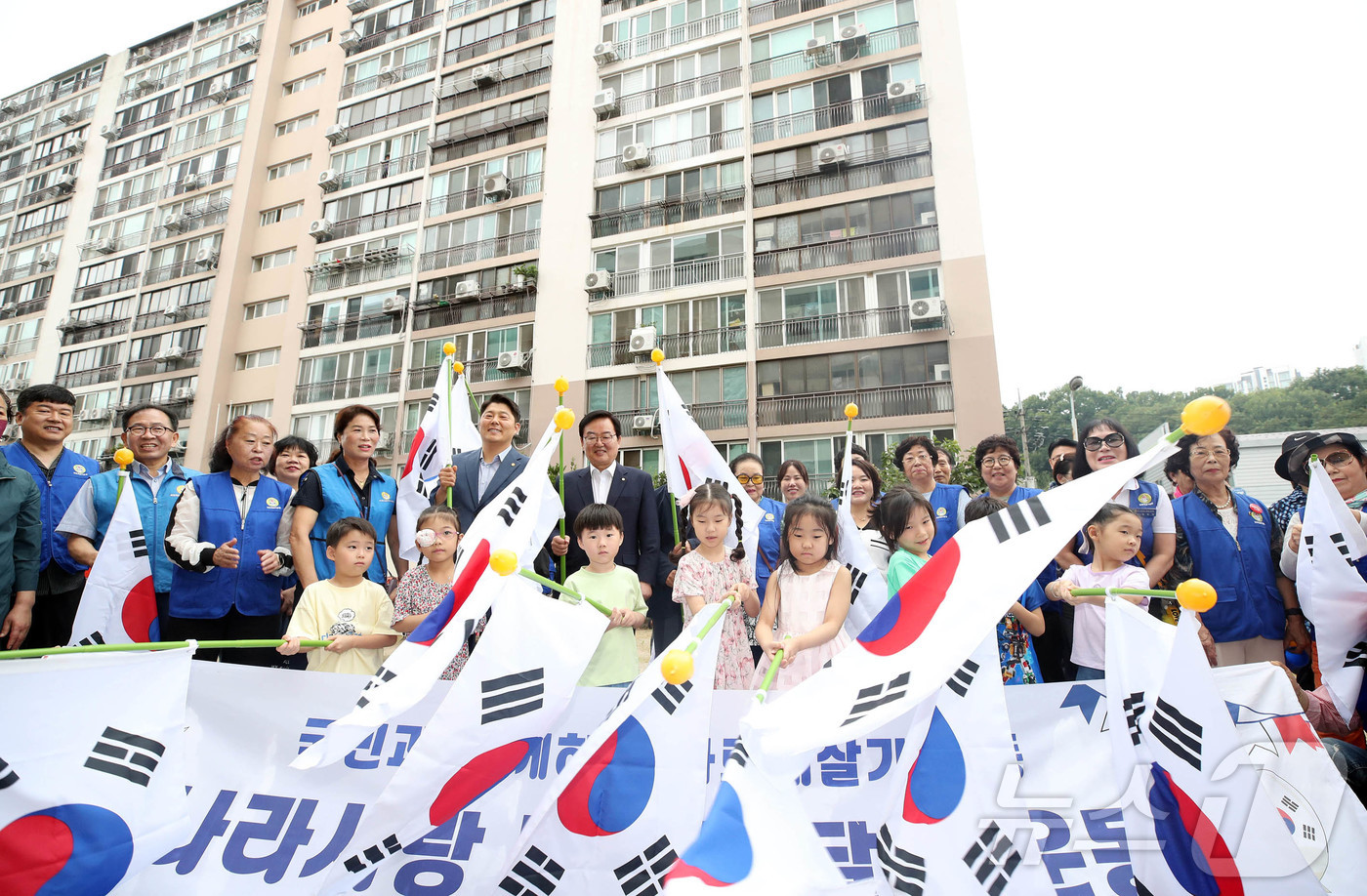 (광주=뉴스1) 박지현 기자 = 제헌절을 하루 앞둔 16일 광주 북구 신안동 중흥파크에서 열린 태극기 마을 조성 행사에서 문인 북구청장과 바르게살기운동북구협의회가 주민들에게 태극기 …