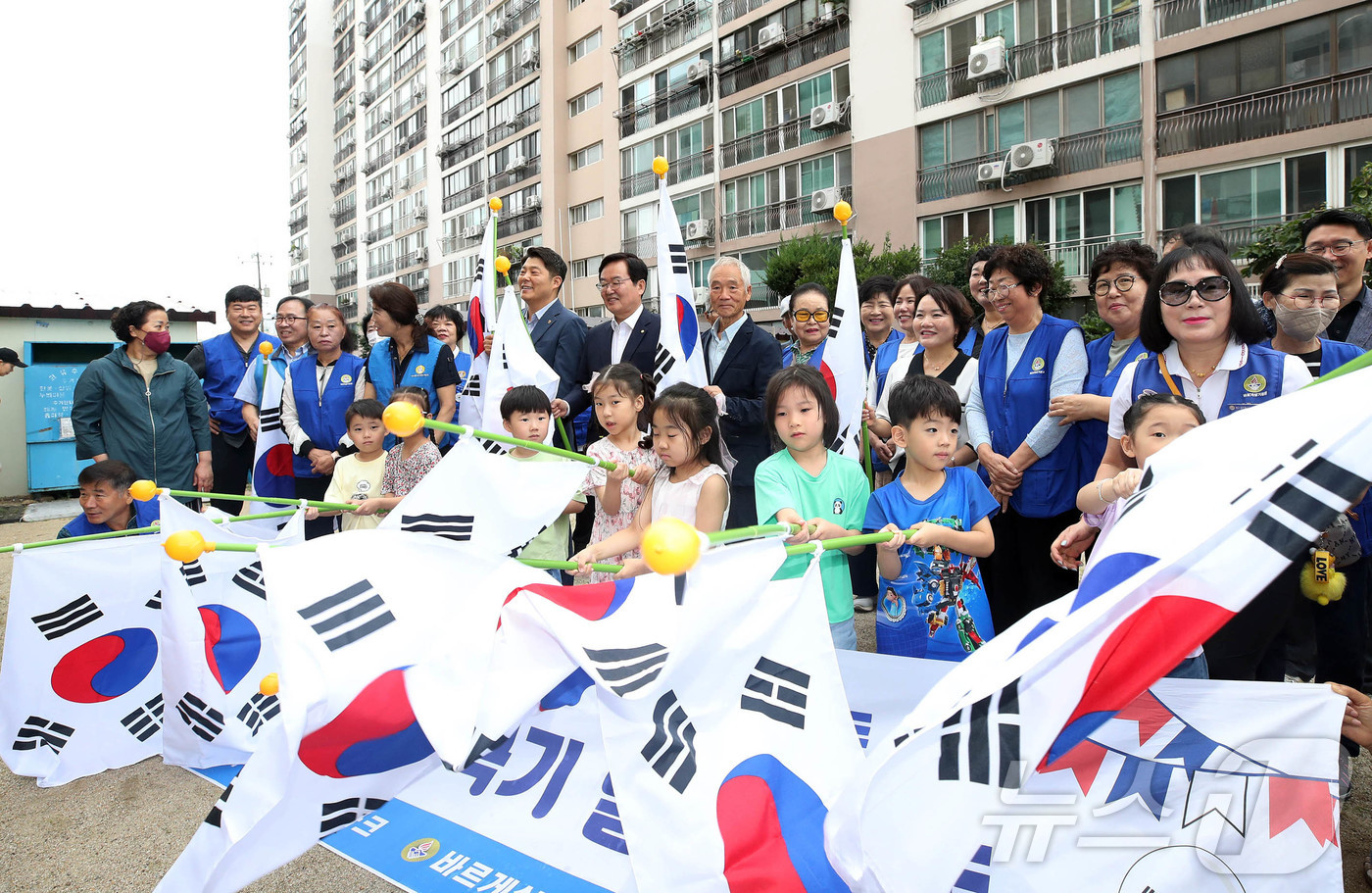(광주=뉴스1) 박지현 기자 = 제헌절을 하루 앞둔 16일 광주 북구 신안동 중흥파크에서 열린 태극기 마을 조성 행사에서 문인 북구청장과 바르게살기운동북구협의회가 주민들에게 태극기 …