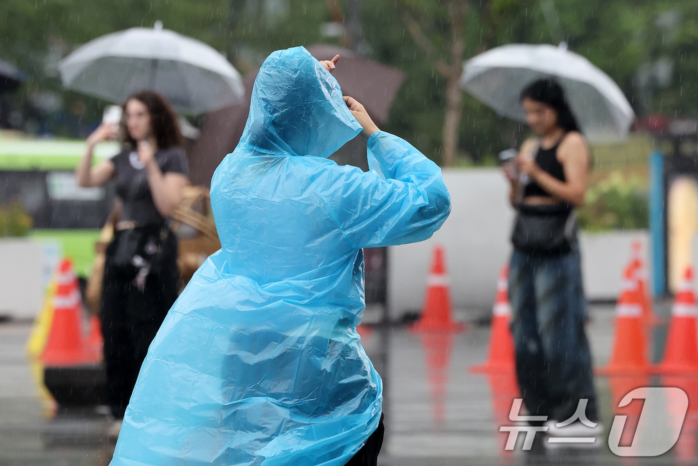 (서울=뉴스1) 이동해 기자 = 비가 내린 16일 서울 종로구 광화문광장에서 시민들이 우의를 입은 한 시민이 발걸음을 재촉하고 있다. 2025.7.16/뉴스1