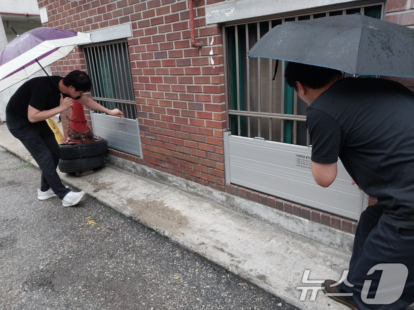 (서울=뉴스1) = 16일 서울 송파구 주택가에서 마천2동 주민자치센터 관계자들이 장마철 집중호우에 대비해 수해예방용 물막이판을 점검하고 있다. (송파구 제공. 재판매 및 DB 금 …