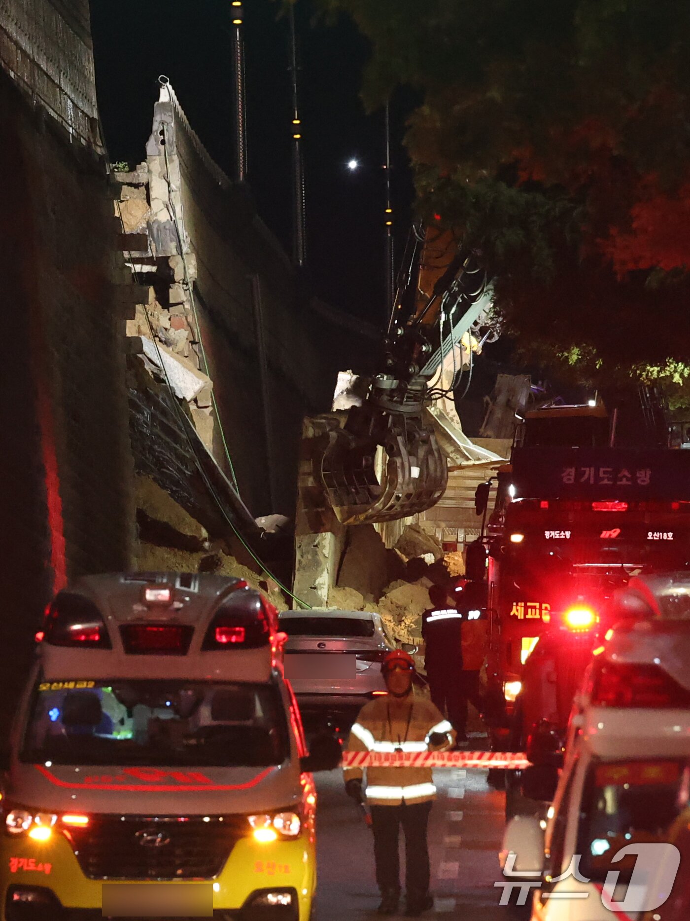 본문 이미지 - 16일 오후 경기 오산시 가장교차로 고가도로 옹벽이 무너져 소방관들이 매몰된 차량구조작업을 하고 있다. 2025.7.16/뉴스1 ⓒ News1 김영운 기자