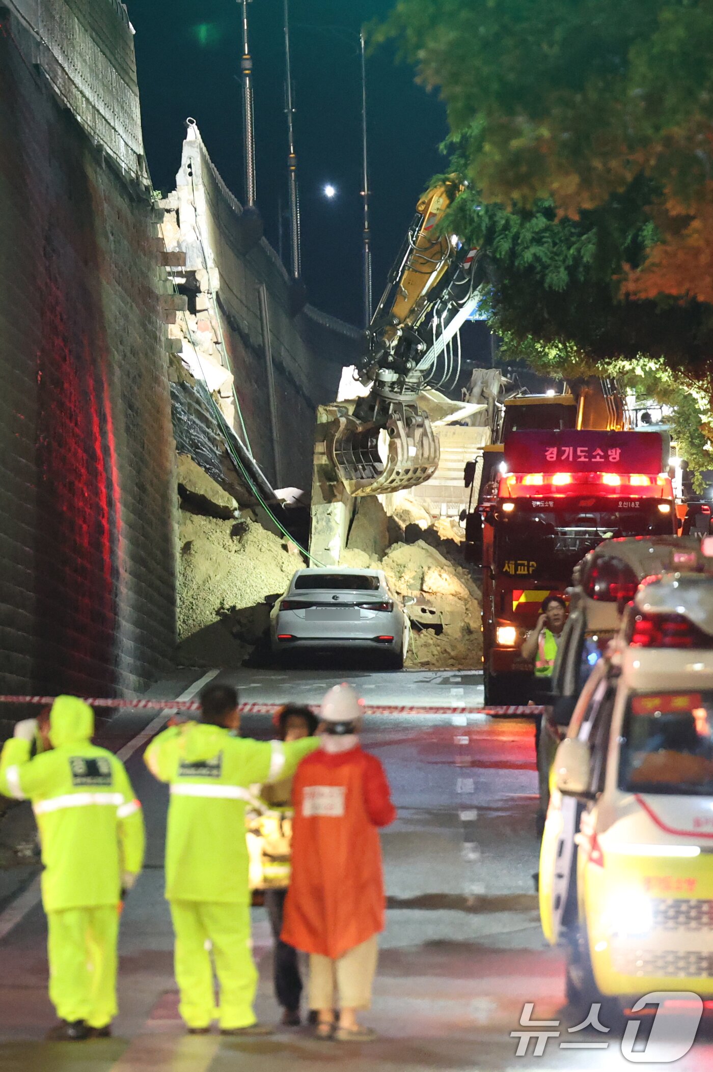 본문 이미지 - 16일 오후 경기 오산시 가장교차로 고가도로 옹벽이 무너져 소방관들이 매몰된 차량구조작업을 하고 있다. 2025.7.16/뉴스1 ⓒ News1 김영운 기자