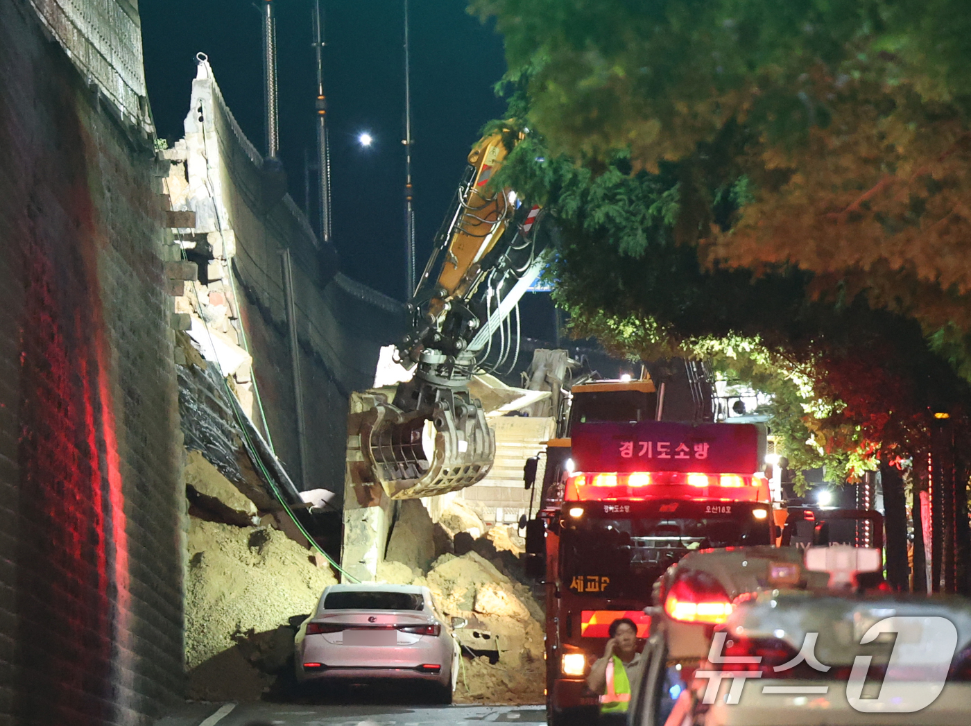(오산=뉴스1) 김영운 기자 = 16일 오후 경기 오산시 가장교차로 고가도로 옹벽이 무너져 소방관들이 매몰된 차량구조작업을 하고 있다. 2025.7.16/뉴스1