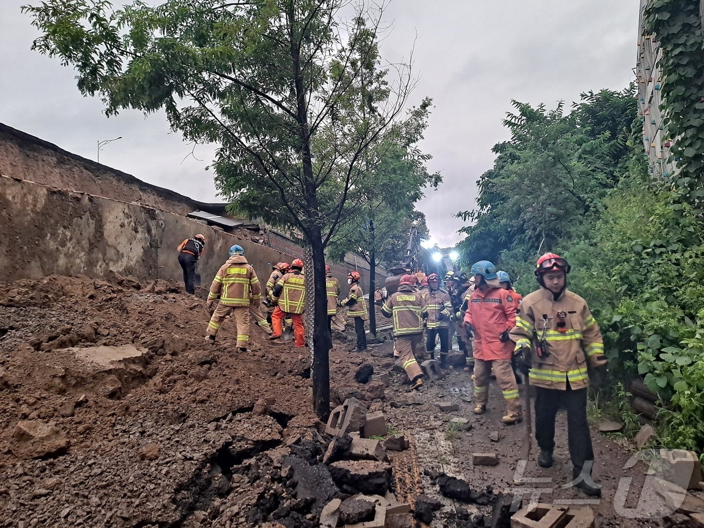 (오산=뉴스1) 김기현 기자 = 16일 오후 경기 오산시 가장교차로 고가도로 옹벽이 무너져 소방관들이 매몰된 차량 구조작업을 하고 있다. (경기도소방재난본부 제공. 재판매 및 DB …