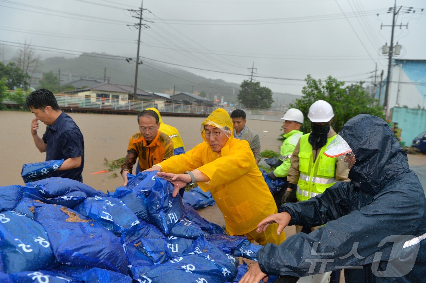 (홍성=뉴스1) 이동원 기자 = 이용록 홍성군수가 17일, 갈산교 범람으로 침수 피해를 입은 갈산전통시장 일원에서 주민·갈산면 직원들과 함께 모래주머니를 활용한 긴급 복구 작업에 …
