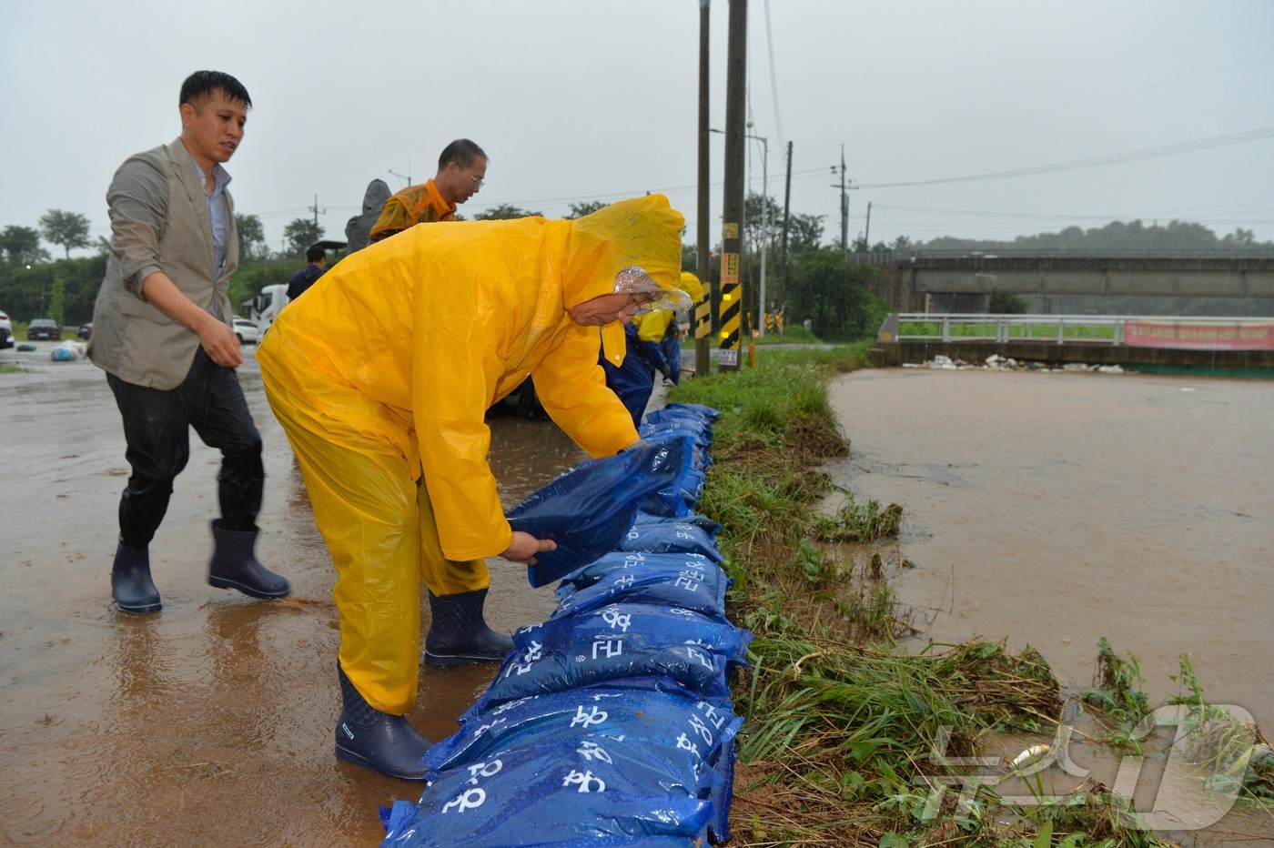 (홍성=뉴스1) 이동원 기자 = 이용록 홍성군수가 17일, 갈산교 범람으로 침수 피해를 입은 갈산전통시장 일원에서 주민·갈산면 직원들과 함께 모래주머니를 활용한 긴급 복구 작업에 …