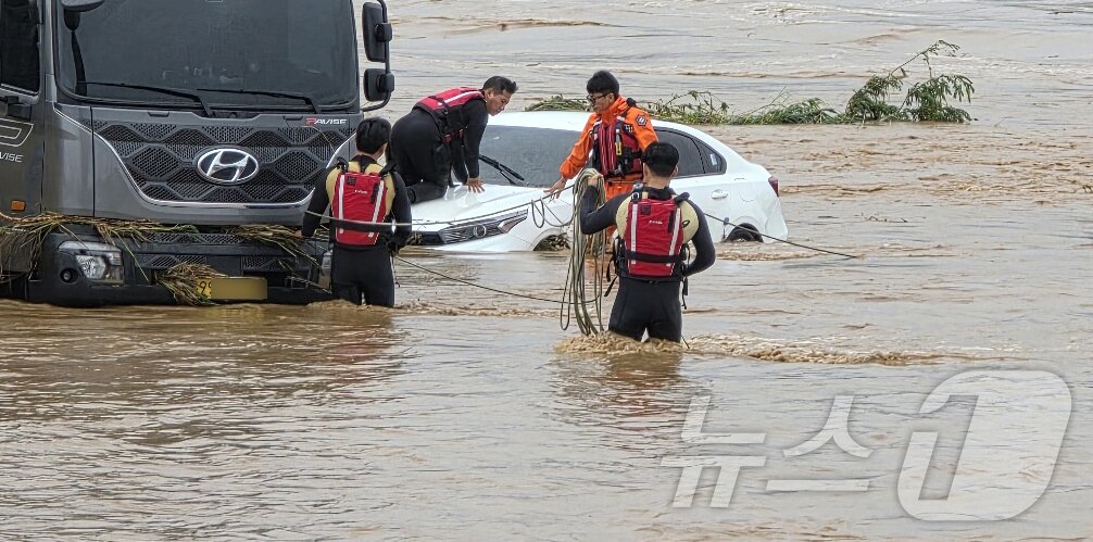 본문 이미지 - 밤사이 쏟아진 집중폭우로 침수 피해가 발생한 17일 충남 아산시 배방읍 곡교천변에서 소방대원들이 불어난 빗물에 쓰러진 시설물과 침수차량을 살펴보고 있다. 2025.7.17/뉴스1 ⓒ News1 이시우 기자
