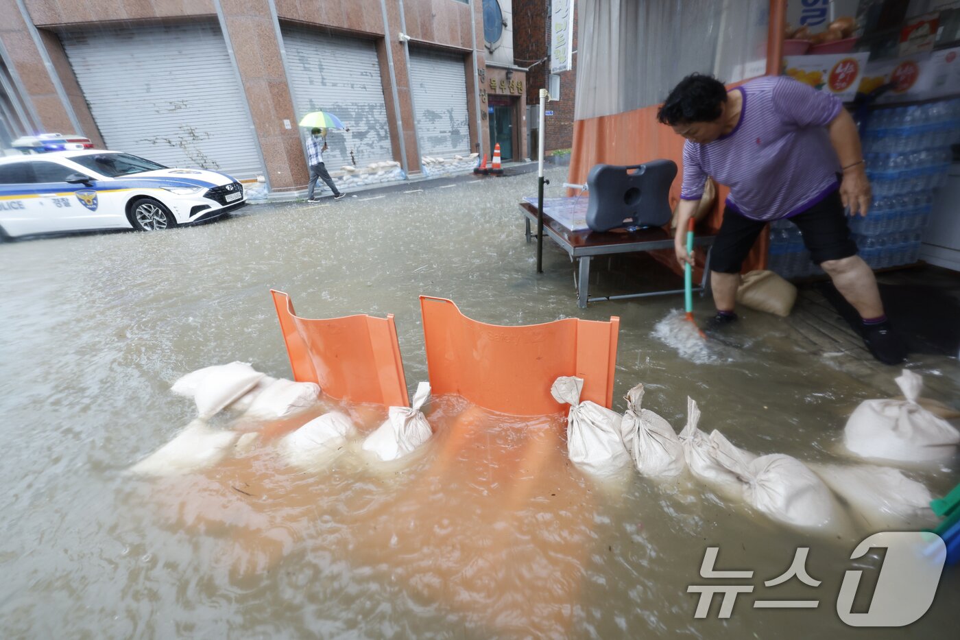 본문 이미지 - 호우경보가 발효된 17일 광주 남구 백운동 일대의 상가가 침수돼 주인이 가게앞 빗물을 쓸어내고 있다. 2025.7.17/뉴스1 ⓒ News1 김태성 기자