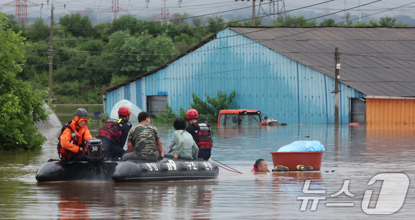 (예산=뉴스1) 김기태 기자 = 17일 충남 예산군 고덕면 용리에서 중앙119구조본부 충청강원 119특수구조대 대원들이 보트로 주민을 구조하고 있다. 2025.7.17/뉴스1