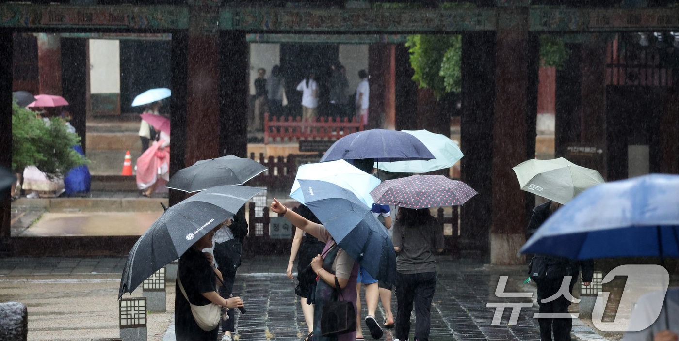 (전주=뉴스1) 유경석 기자 = 전북 전 지역에 호우특보 발효된 17일 전북 전주시 한옥마을 경기전에서 우산을 쓴 관광객들이 발걸음을 재촉하고 있다. 2025.7.17/뉴스1
