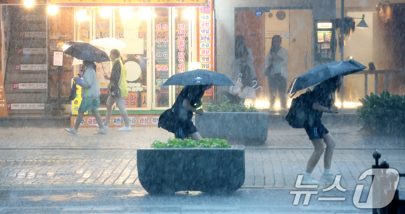 (전주=뉴스1) 유경석 기자 = 전북 전 지역에 호우특보 발효된 17일 전북 전주시 한옥마을 경기전에서 우산을 쓴 관광객들이 발걸음을 재촉하고 있다. 2025.7.17/뉴스1