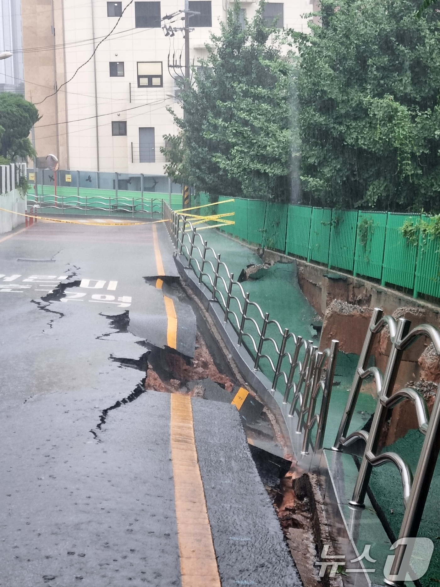 (광주=뉴스1) 이승현 기자 = 시간당 80㎜의 극한 호우가 쏟아진 17일 오후 2시 20분쯤 광주 계림동 광주고등학교 인근 인도와 도로가 갈라졌다는 신고가 접수됐다. 사진은 통제 …