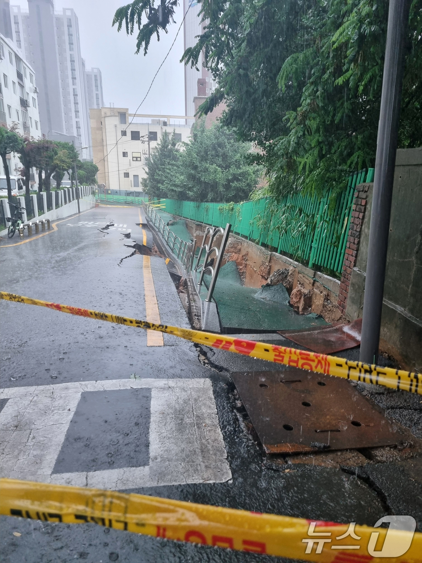(광주=뉴스1) 이승현 기자 = 시간당 80㎜의 극한 호우가 쏟아진 17일 오후 2시 20분쯤 광주 계림동 광주고등학교 인근 인도와 도로가 갈라졌다는 신고가 접수됐다. 사진은 통제 …