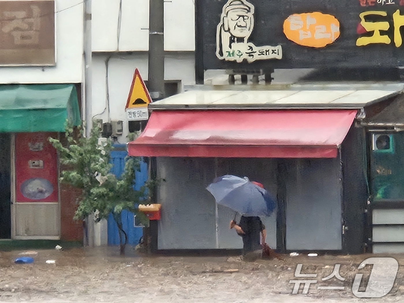 (대구=뉴스1) 신성훈 기자 = 17일 대구 북구 노곡동 일대가 침수돼 상가와 차량이 물이 잠겼다. 주민이 물길을 헤치고 걸어가고 있다.(독자 제공.재판매 및 DB금지) 2025. …