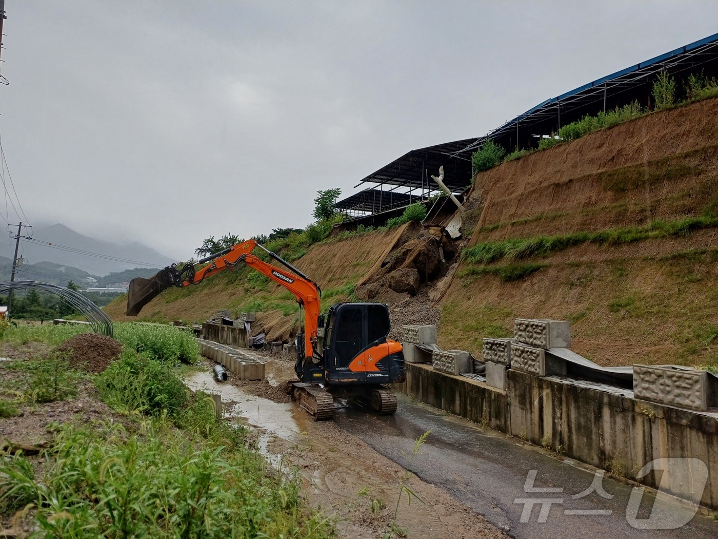 (충주=뉴스1) 윤원진 기자 = 17일 전날부터 내린 집중호우로 충북 충주 금가면 유송리의 한 축사 사면이 붕괴돼 복구 작업을 진행하고 있다.(충주시 제공. 재판매 및 DB금지)/ …