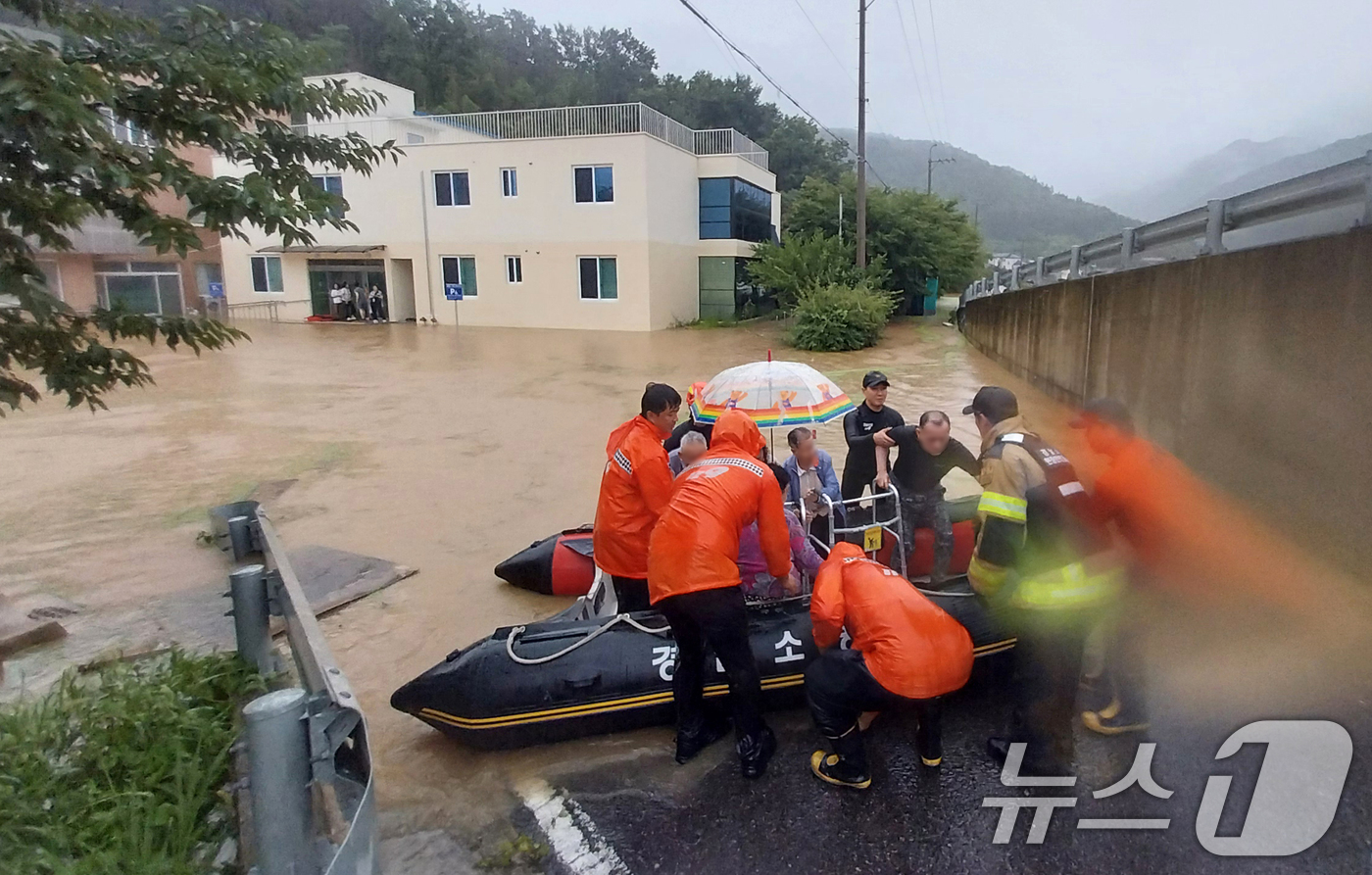 (산청=뉴스1) 윤일지 기자 = 17일 경남 밀양시 무안면 한 노인요양원 일대가 침수돼 소방대원들이 환자들을 다른 병원으로 전원시키기 위해 고무보트를 이용해 구조하고 있다. (경남 …