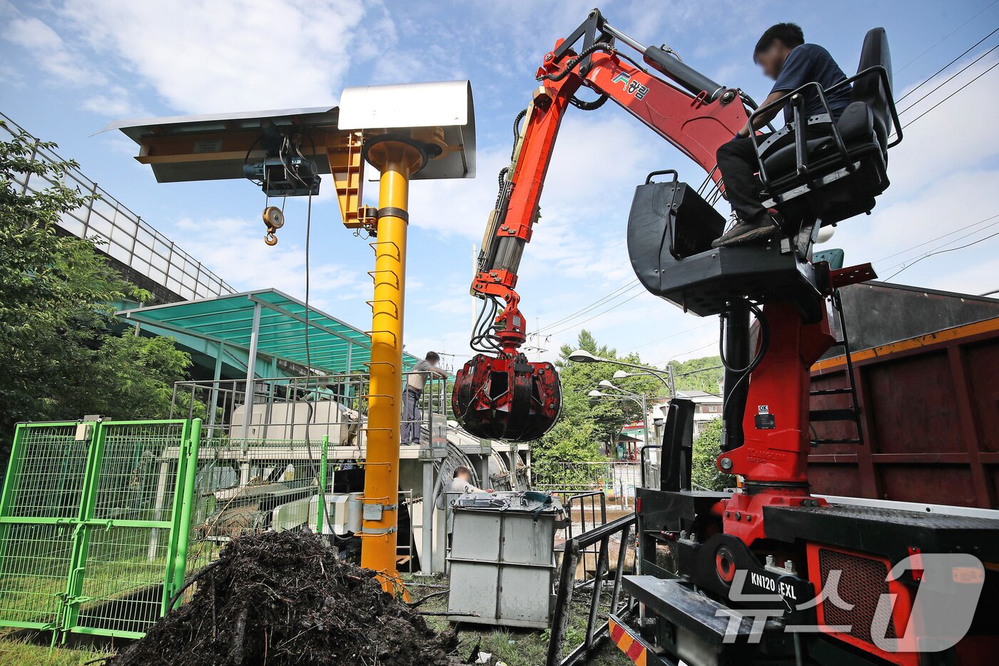 본문 이미지 - 18일 오전 대구 북구 노곡동 빗물펌프장에서 시설 관계자들이 집게크레인을 동원해 전날 집중호우 때 쌓인 쓰레기와 나뭇가지 등 찌꺼기를 제거하고 있다. 2025.7.18/뉴스1 ⓒ News1 공정식 기자