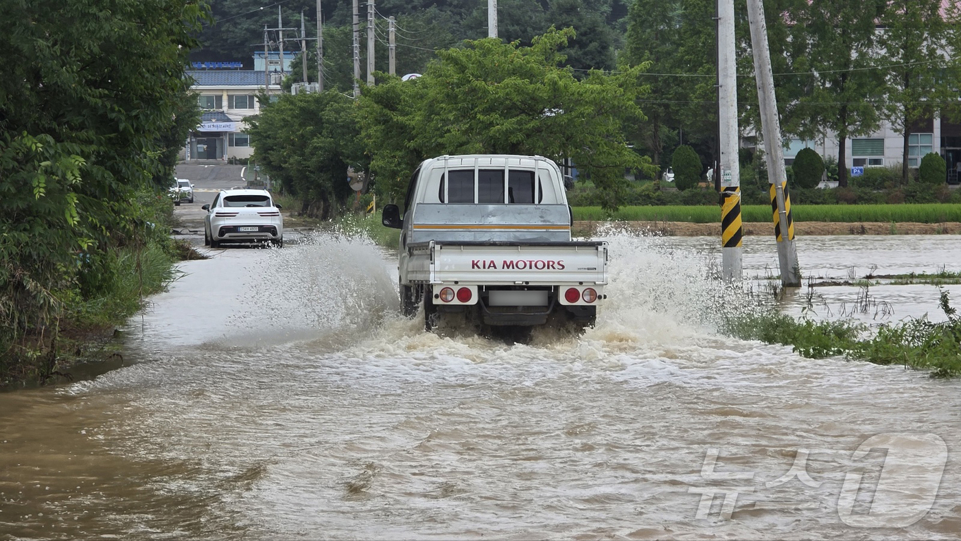 (아산=뉴스1) 이시우 기자 = 18일 충남 아산시 염치읍 행정복지센터 일대가 지난 폭우로 물에 잠겨 이 일대를 지나는 차량들이 위태롭게 운행하고 있다. 2025.7.18/뉴스1