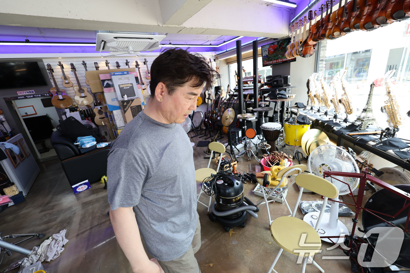 (광주=뉴스1) 박지현 기자 = 18일 광주 북구 용봉동 전남대 후문 일대가 전날 내린 폭우로 침수된 가운데 한 상가 내부의 악기들이 물에 젖어 상인이 이를 수습하고 있다. 202 …