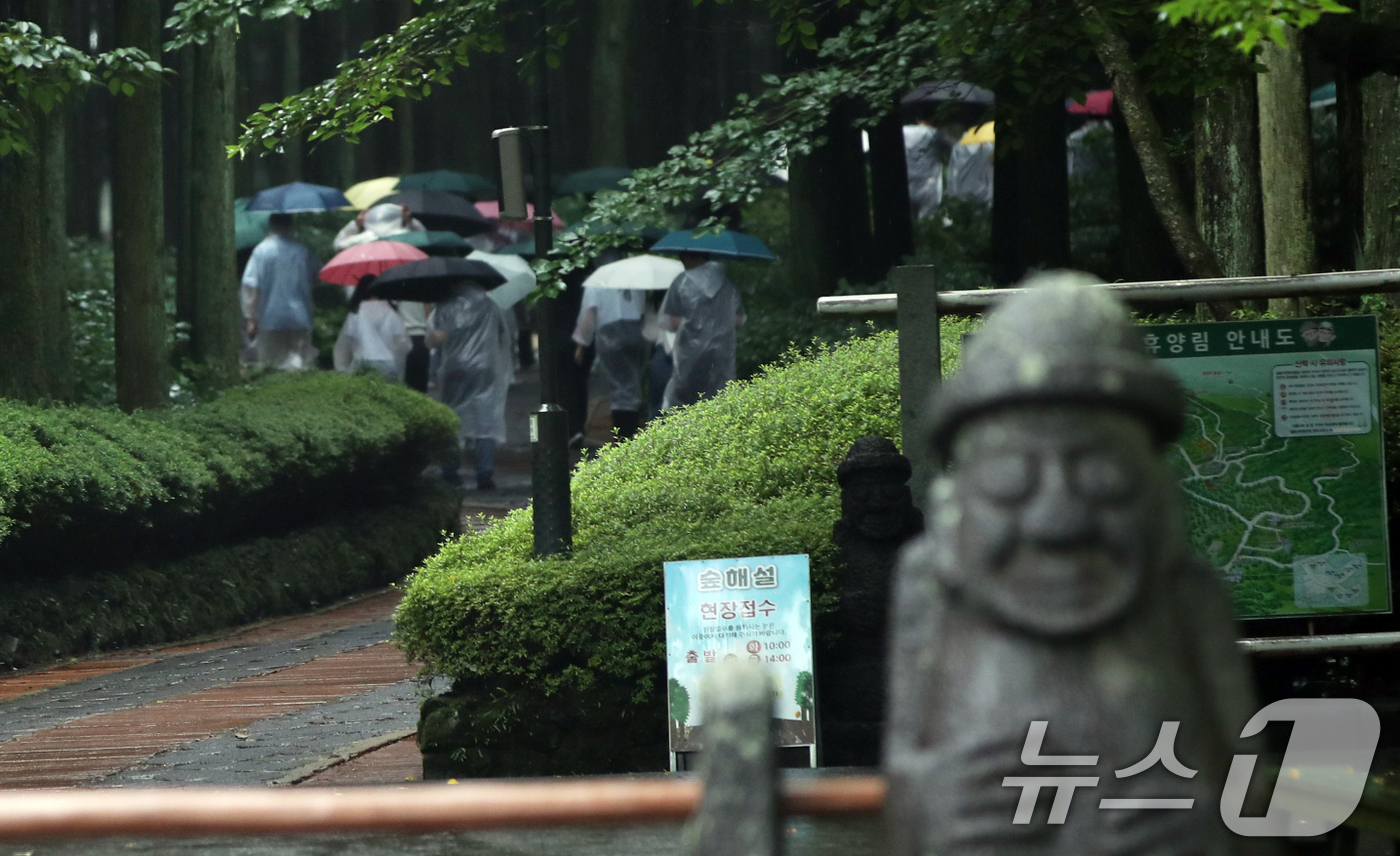 (제주=뉴스1) 오현지 기자 = 제주도 산지·북부 중산간에 호우특보가 내려진 18일 오후 제주시 봉개동 절물자연휴양림에 많은 비가 내려 탐방객이 급히 발걸음을 옮기고 있다. 202 …