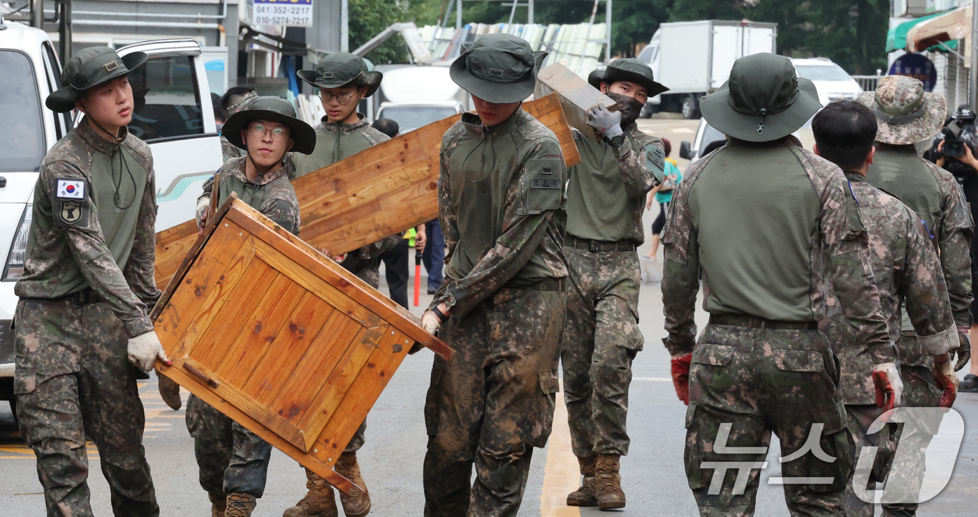 (당진=뉴스1) 김기태 기자 = 육군 32사단 장병들이 18일 집중호우로 침수된 충남 당진시장에서 복구작업을 하고 있다. 2025.7.18/뉴스1