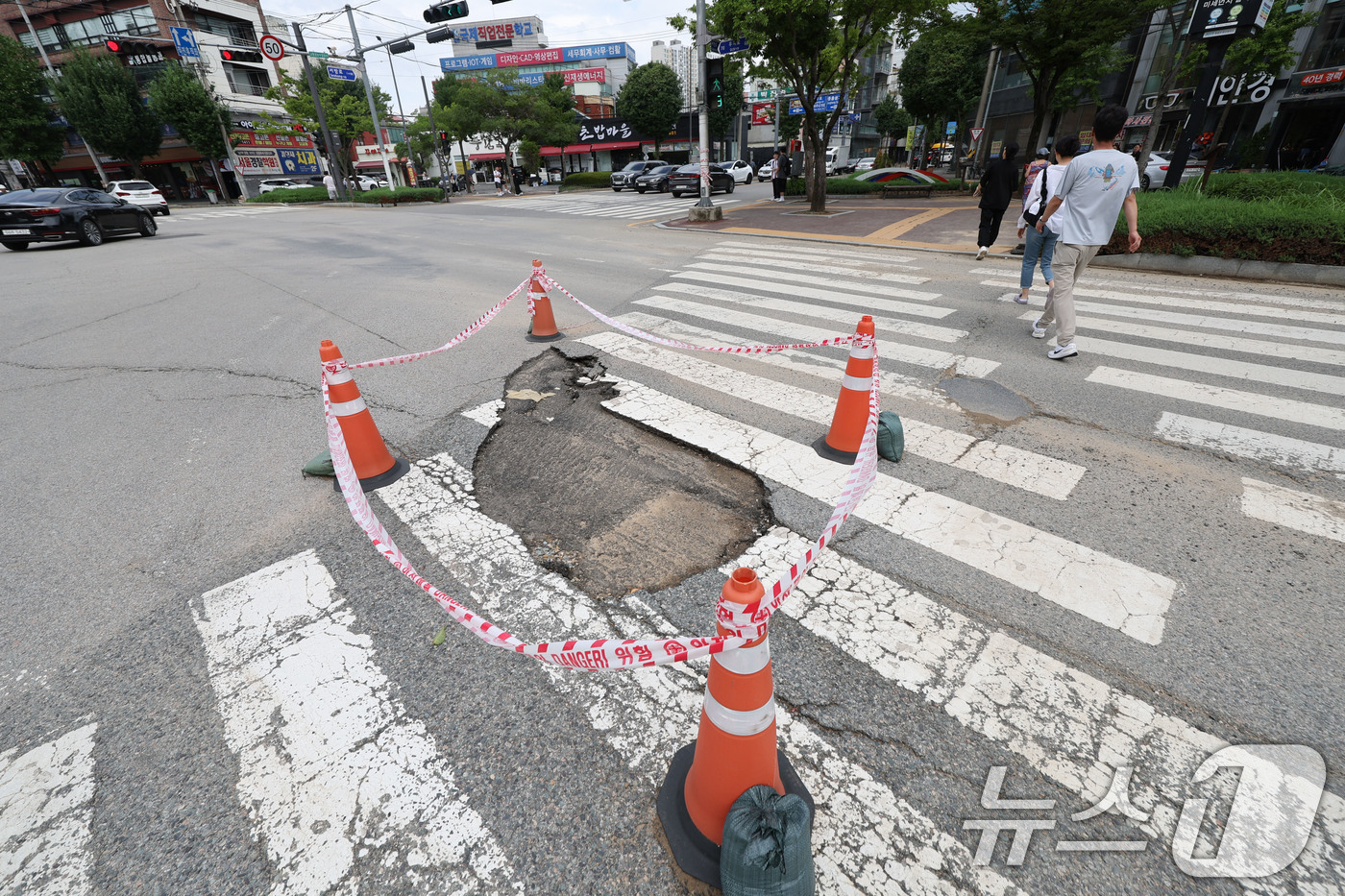 (광주=뉴스1) 박지현 기자 = 전날 내린 기록적인 폭우로 18일 광주 북구 용봉동 북구청 사거리 일대 도로가 깨져 통제되고 있다. 2025.7.18/뉴스1
