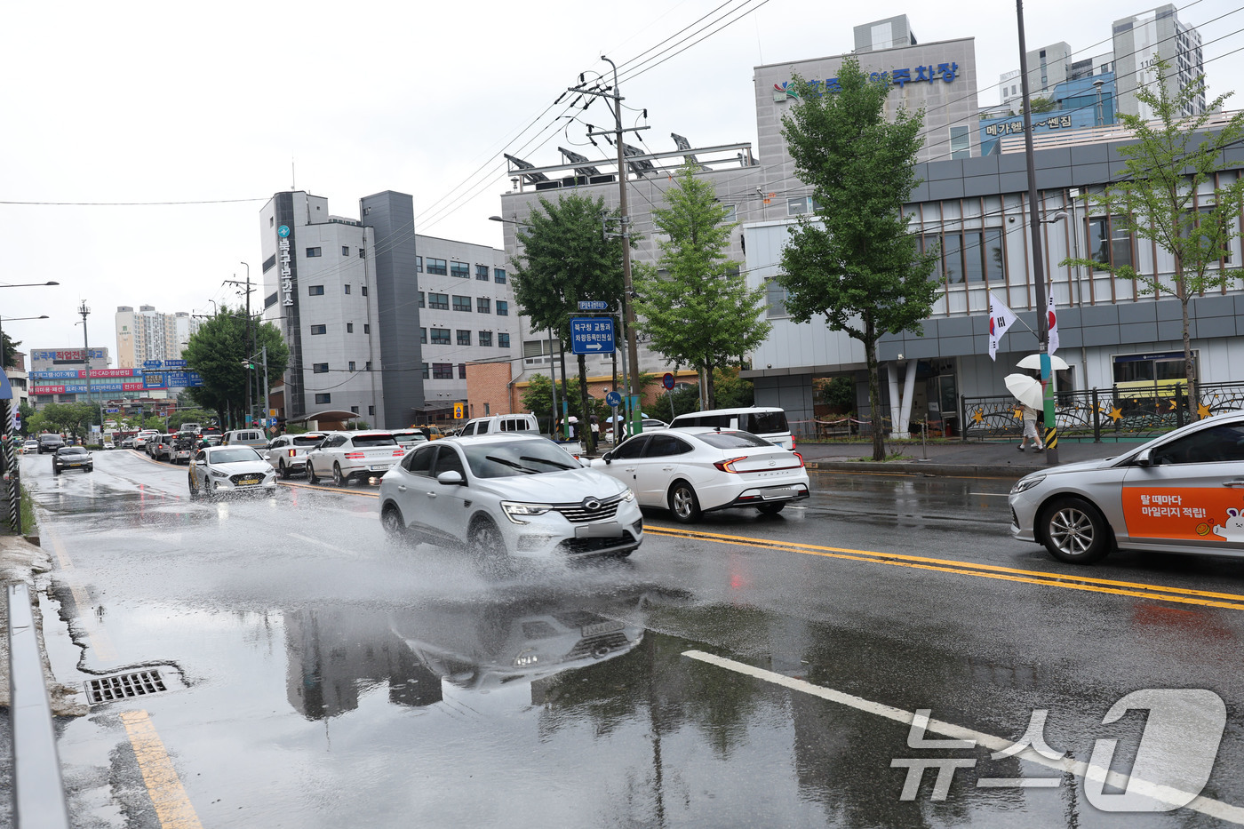 (광주=뉴스1) 박지현 기자 = 호우주의보에 내려진 18일 광주 북구 용봉동 북구청 사거리가 일대에 빗물 고인 도로를 자동차가 지나다니고 있다. 2025.7.18/뉴스1