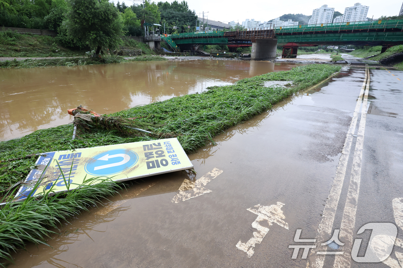 (광명=뉴스1) 민경석 기자 = 19일 경기 광명시 목감천이 밤사이 내린 집중호우로 한때 범람해 산책로 일대에 토사의 흔적이 남아 있다. 2025.7.19/뉴스1