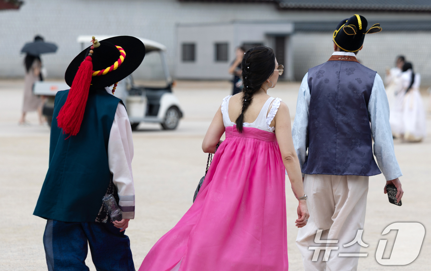 (서울=뉴스1) 이승배 기자 = 무더운 날씨가 이어지고 있는 2일 서울 종로구 경복궁을 찾은 한 외국인 관람객이 더위에 한복 저고리를 벗고 발걸음을 옮기고 있다. 2025.7.2/ …