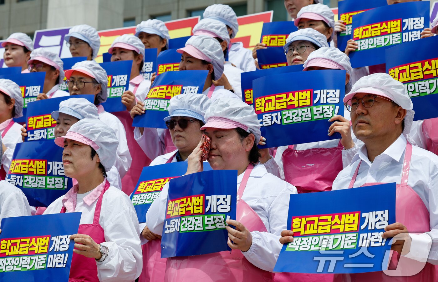 본문 이미지 - 작업복을 입은 학교급식조리사들이 2일 서울 여의도 국회 본청 계단에서 열린 민주노총 서비스연맹 전국학교비정규직노동조합 '학교급식 노동자 건강과 안전 확보를 위한 학교급식법 개정안 발의 기자회견'에서 손팻말을 들고 있다. 2025.7.2/뉴스1 ⓒ News1 안은나 기자