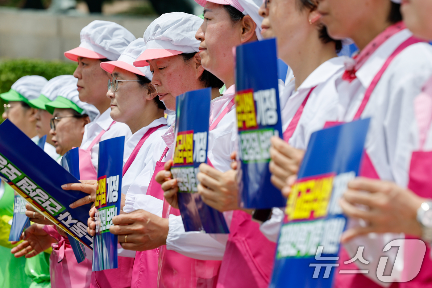 (서울=뉴스1) 안은나 기자 = 작업복을 입은 학교급식조리사들이 2일 서울 여의도 국회 본청 계단에서 열린 민주노총 서비스연맹 전국학교비정규직노동조합 '학교급식 노동자 건강과 안전 …