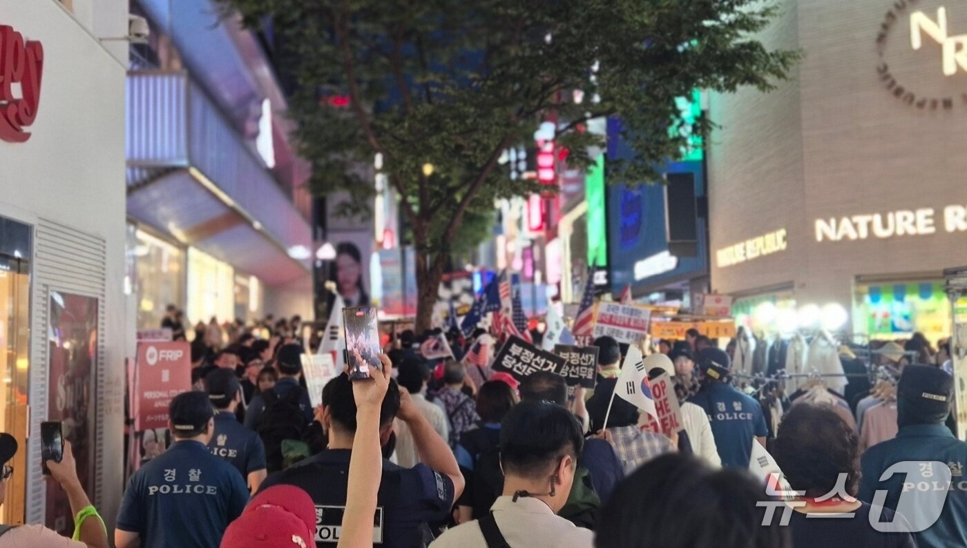 본문 이미지 - 2일 오후 서울 중구 명동 거리에서 자유대학 집회 참가자들이 부정선거 의혹을 제기하며 외국인 관광객들 사이로 행진하고 있다.  ⓒ 뉴스1 남해인 기자