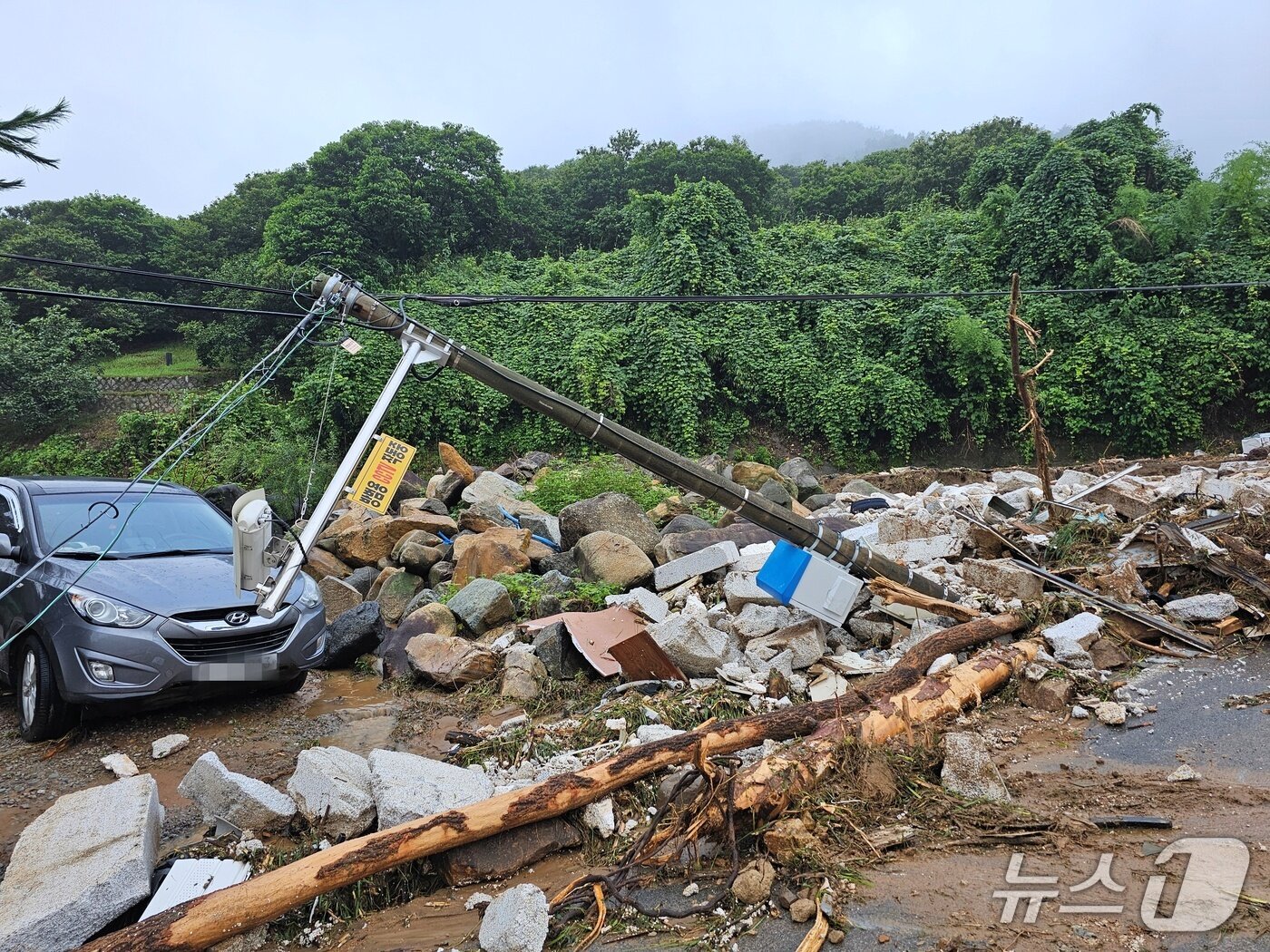 본문 이미지 - 산청군 부리마을 산사태에 기울어진 전신주와 파손된 차량. 2025.7.20/뉴스1 한송학기자