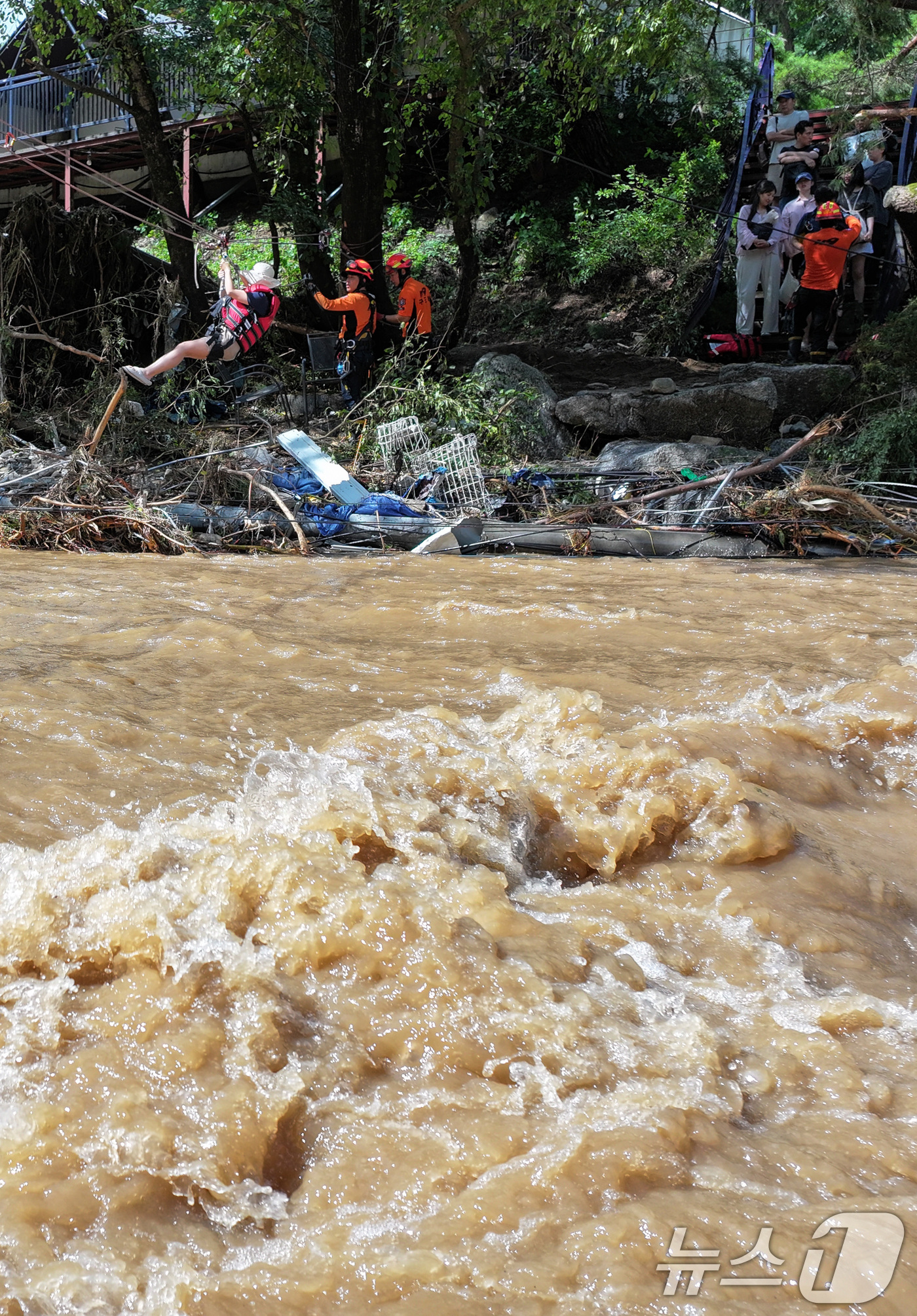(가평=뉴스1) 신웅수 기자 = 20일 경기 가평군 마일리의 한 캠핑장에 고립된 시민들이 소방 로프를 타고 탈출하고 있다. 2025.7.20/뉴스1