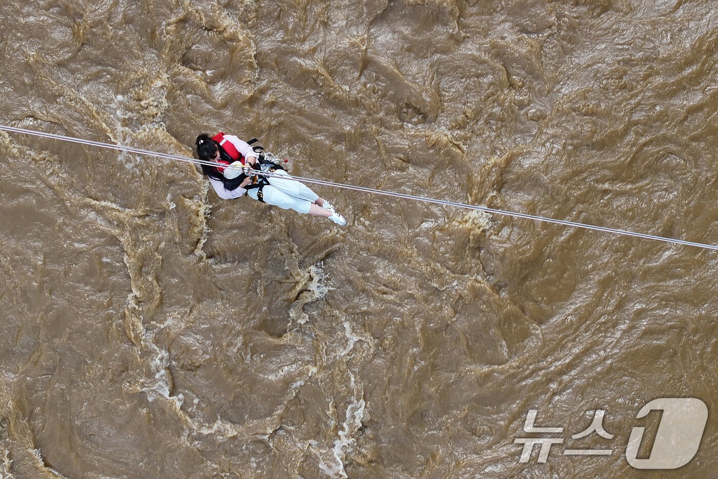 본문 이미지 - 20일 경기 가평군 마일리의 한 캠핑장에 고립된 시민들이 소방 로프를 타고 탈출하고 있다. 2025.7.20/뉴스1 ⓒ News1 신웅수 기자